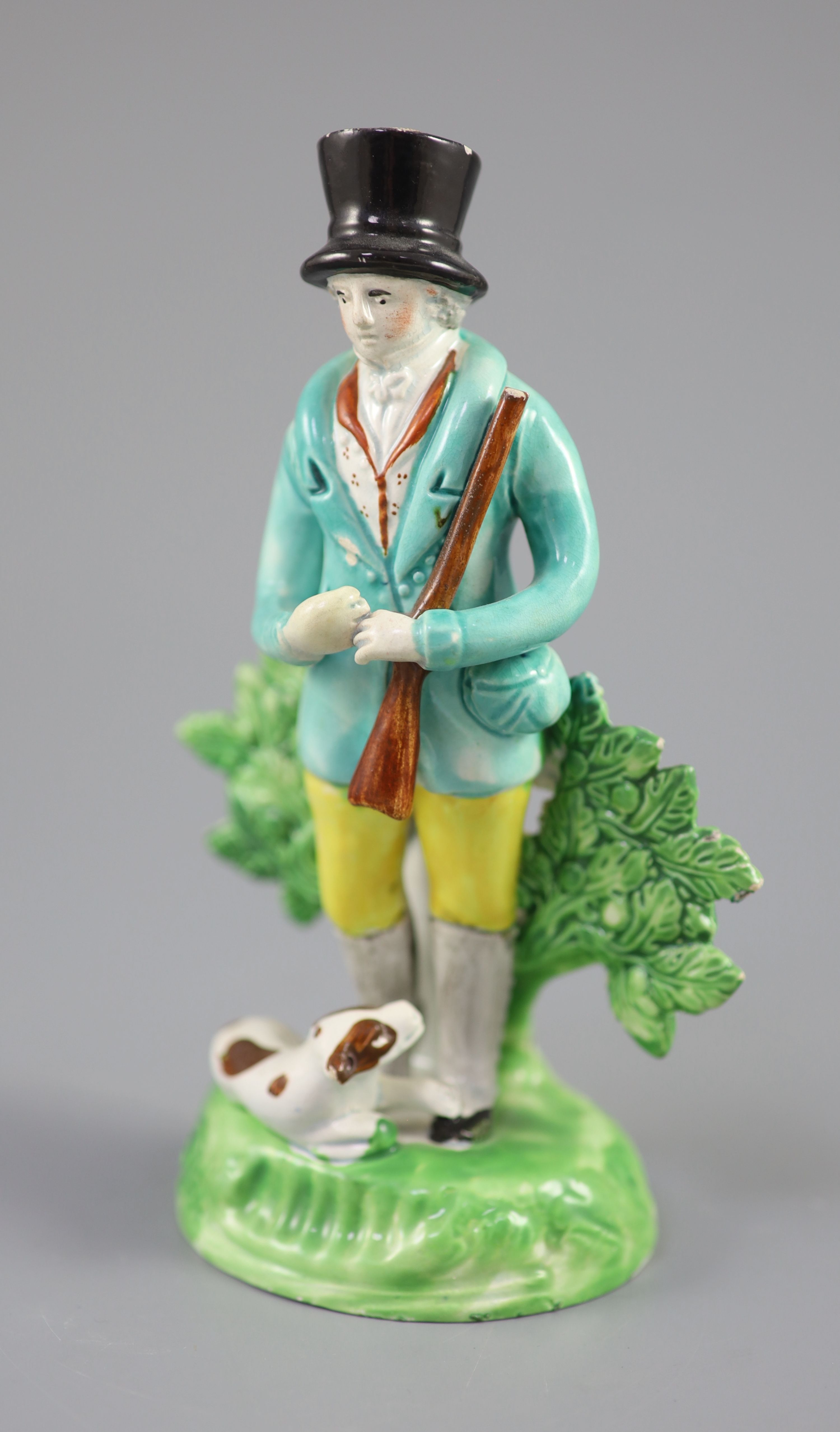 A Staffordshire pearlware group of a hunter with gun and recumbent dog, c.1820-30, 17.5cm high